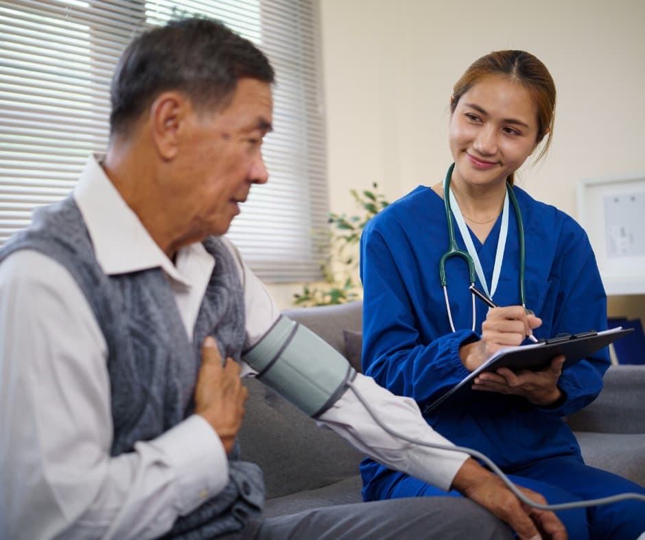 Nurse checking an older patient's blood pressure at home